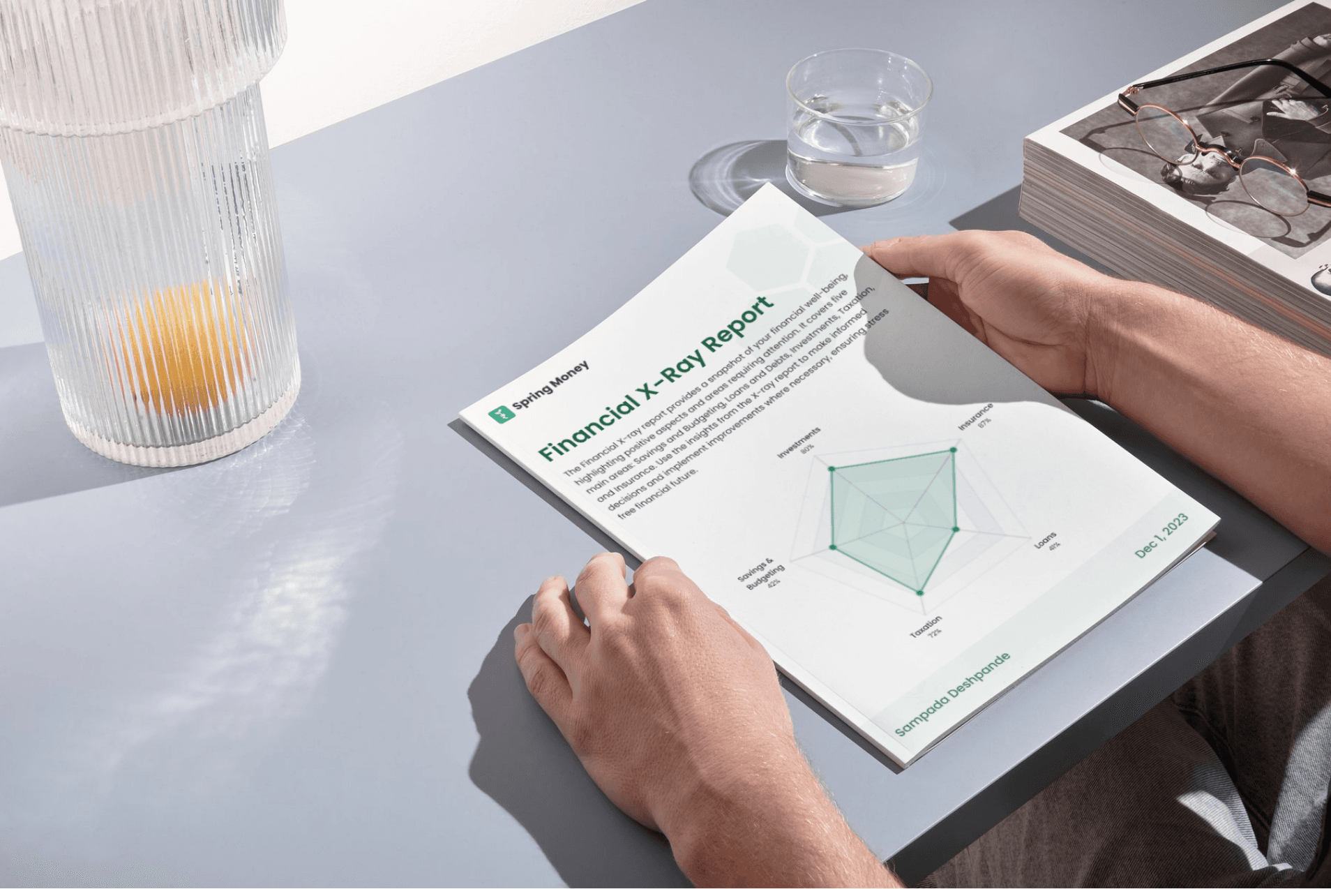 Hands holding a detailed financial x-ray report with spectacles placed beside it, symbolizing clarity and insight into financial analysis provided by Spring Money’s financial x-ray report.